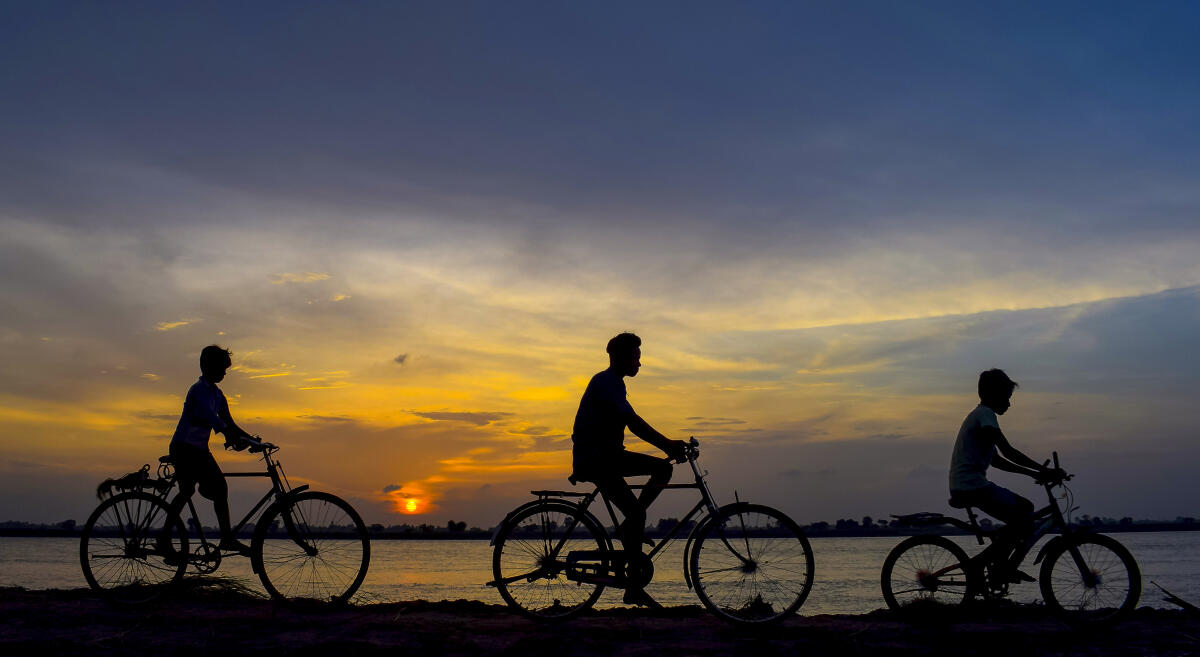 Cyclists are silhouetted against the setting sun, on World Bicycle Day, in Nadia, West Bengal