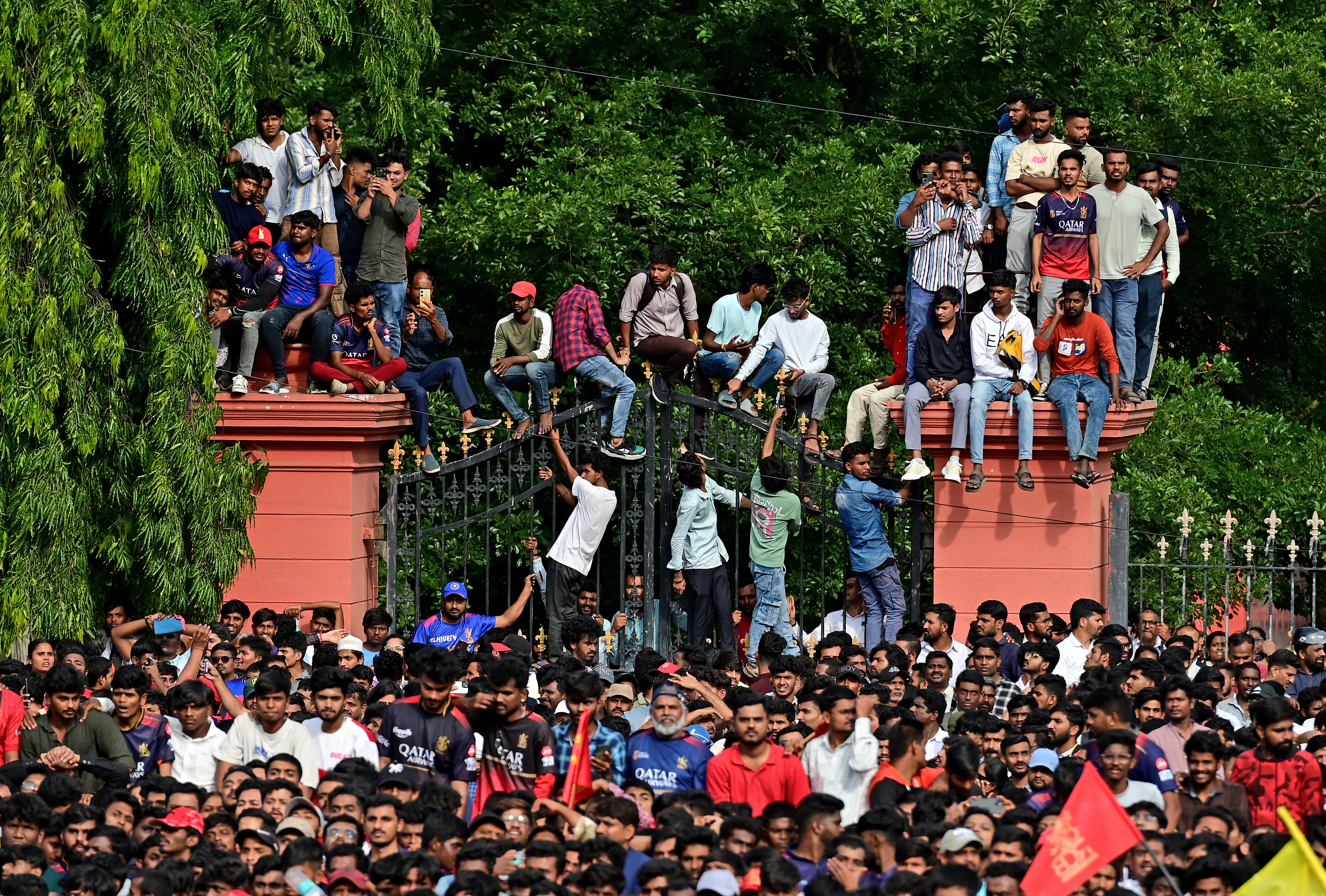 Fans climb up the gate of the High Court and trees to get a glimpse of their favourite players. 