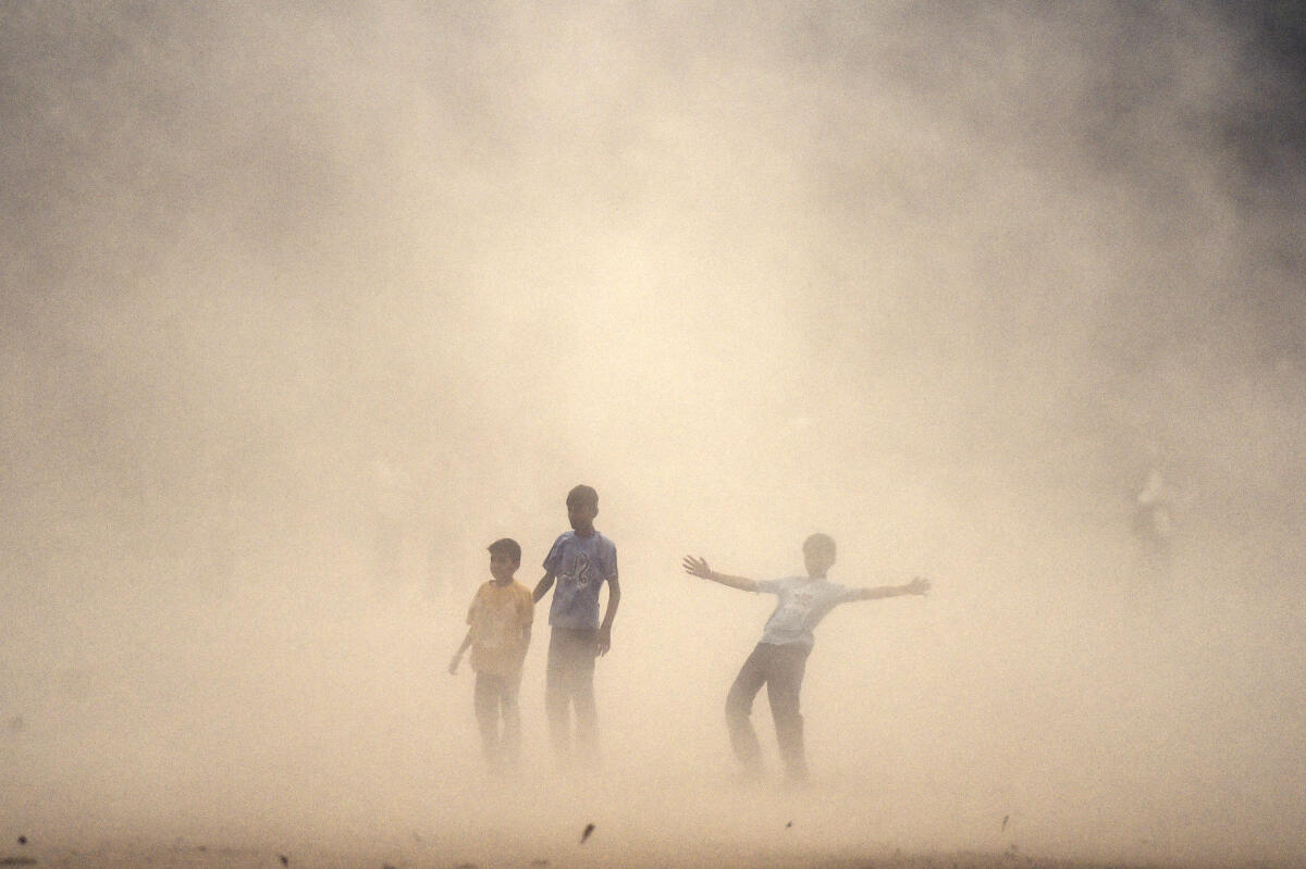 Children play during a dust storm, in Jalandhar