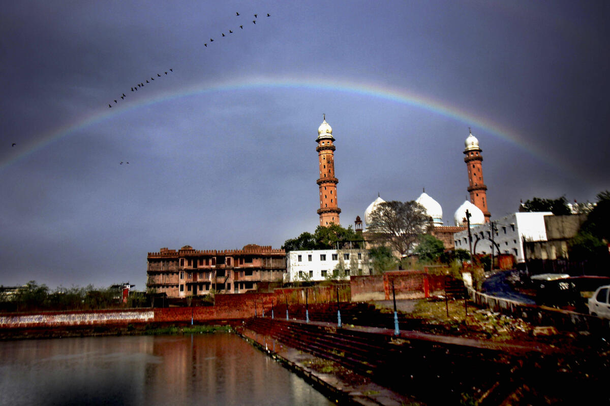 A rainbow forms in the sky after rainfall, in Bhopal