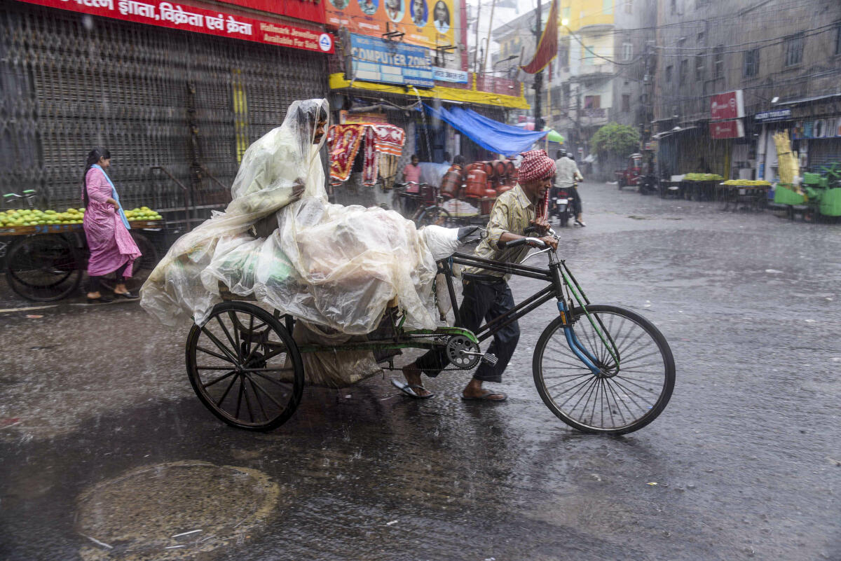 A man pulls his cart amid rainfall, in Patna