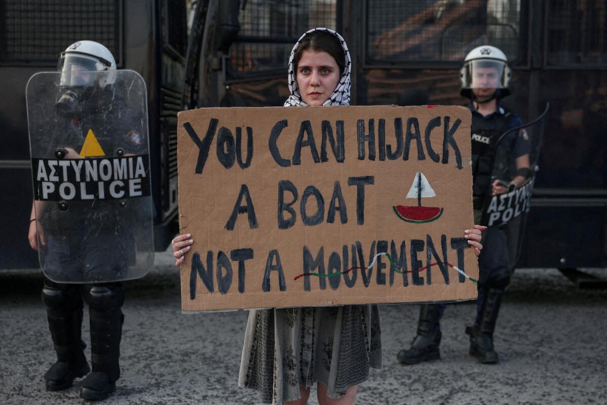 A demonstrator holds a placard as people protest in front of the Israeli embassy in Athens, following the seizure by Israeli forces of the Gaza-bound charity vessel Madleen, operated by pro-Palestinian Freedom Flotilla Coalition, in Athens, Greece, June 9, 2025.