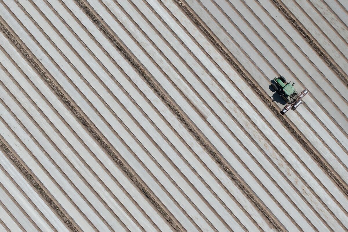 A drone view shows a farmer driving his tractor to work in his field in Saint-Julien-de-Concelles near Nantes, France, June 10, 2025.