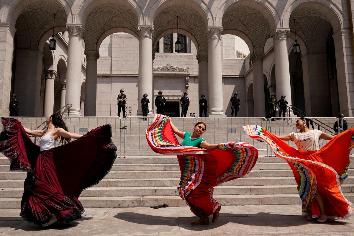 People dance as they protest against federal immigration sweeps, in downtown Los Angeles, California.