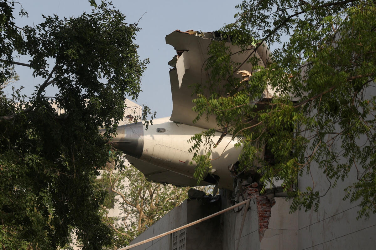 A tail of an Air India Boeing 787 Dreamliner plane that crashed is seen stuck on a building after the incident in Ahmedabad, India, June 12, 2025. 