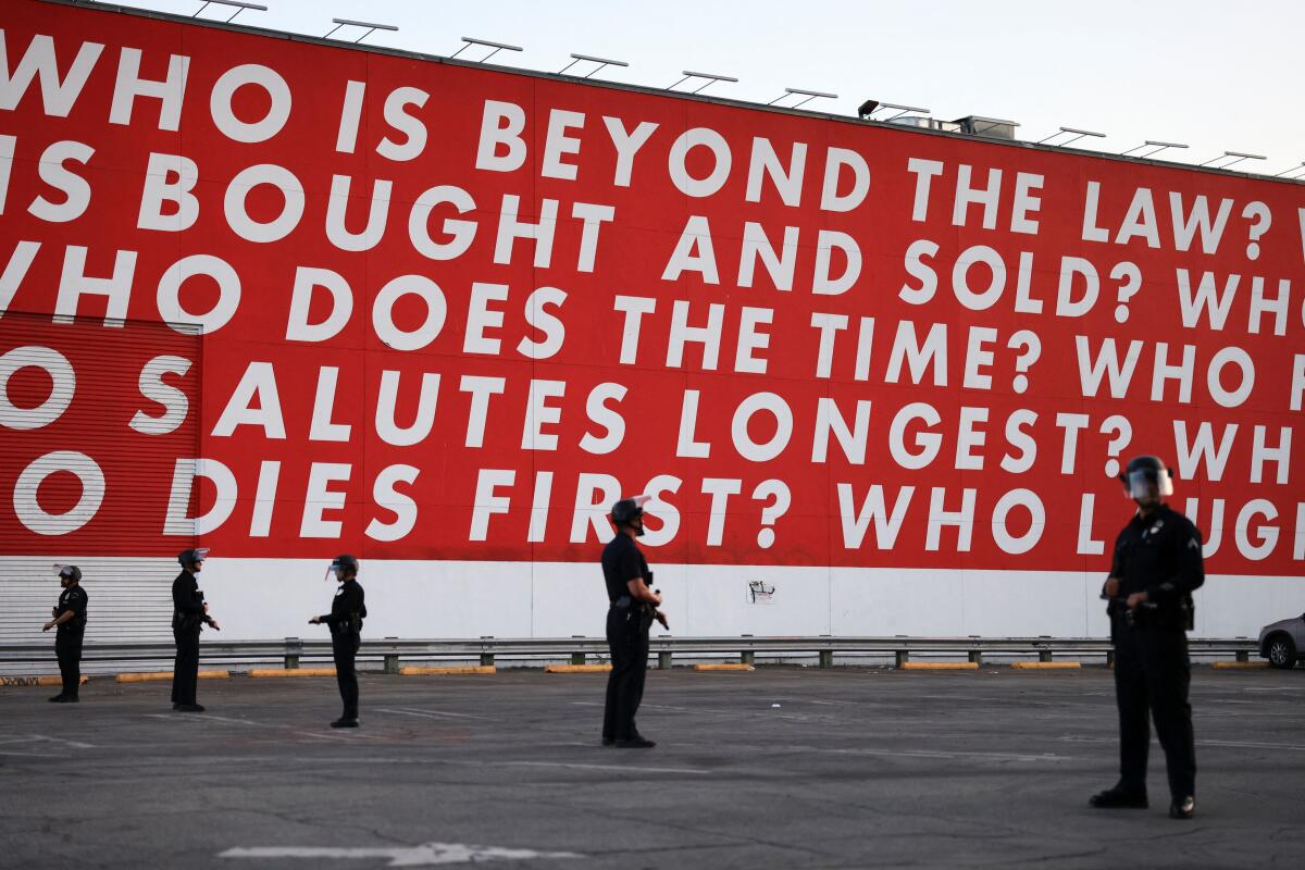 Law enforcement officers stand guard, during a protest against federal immigration sweeps, in Los Angeles, California, US, June 12, 2025