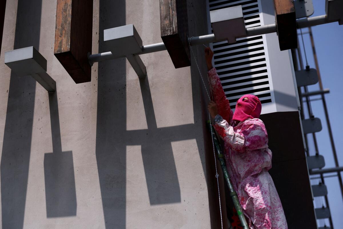 An activist protests against gentrification and speculated new building projects outside Coima headquarters, a leading real estate investment and development firm, in Milan, Italy, June 13, 2025.