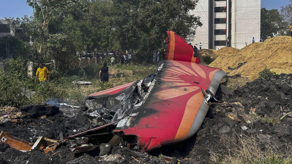  People near the debris of the Air India plane that crashed moments after taking off from the airport, in Ahmedabad 