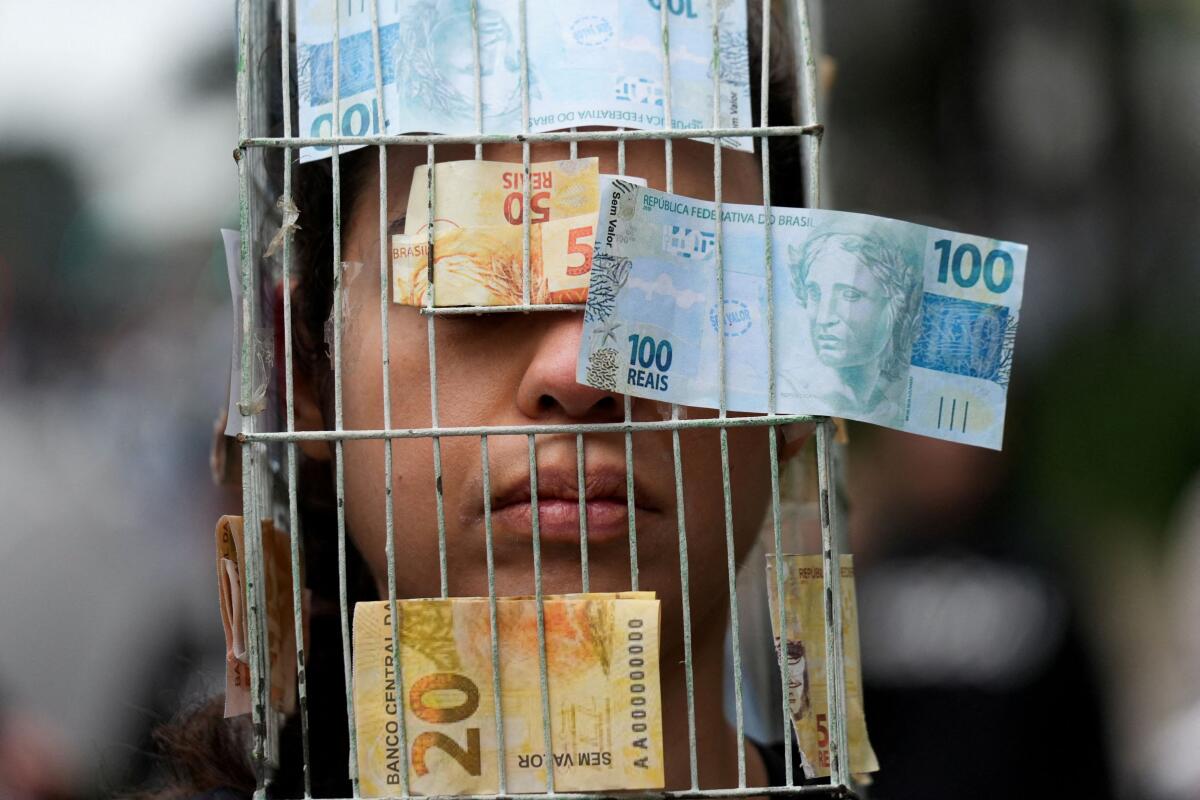 A person wears a costume representing a cage with banknotes attached to it, as animal protection activists protest against the export of live animals, at Paulista Avenue, in Sao Paulo, Brazil June 15, 2025.