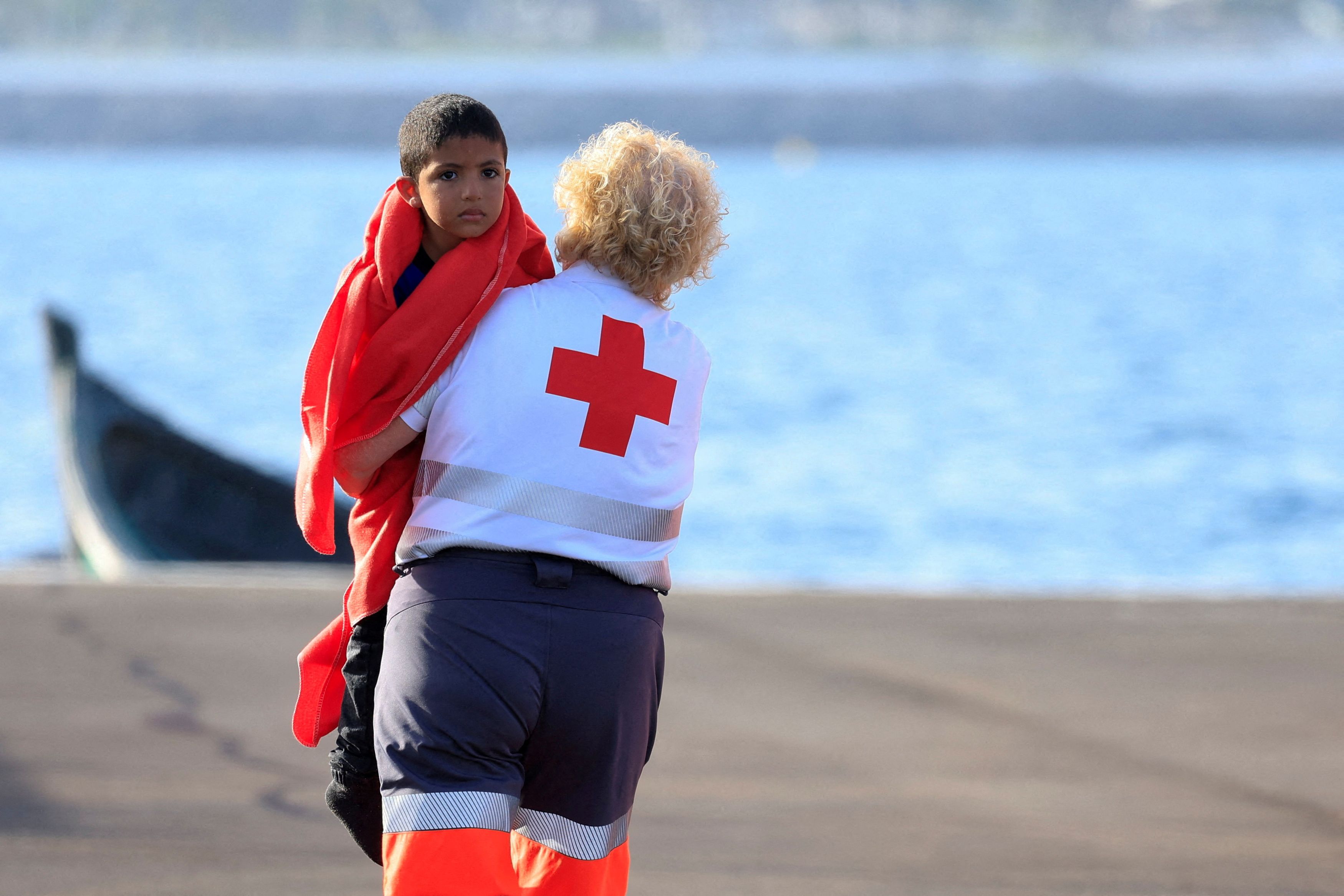A migrant minor is transferred by the Red Cross after disembarking from a Spanish coast guard vessel, in the port of Arguineguin, Spain, June 18, 2025.