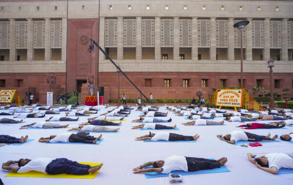 Lok Sabha and Rajya Sabha officials perform yoga during a 'Yoga Shivir', organised on the International Day of Yoga, at the Parliament House complex in New Delhi.