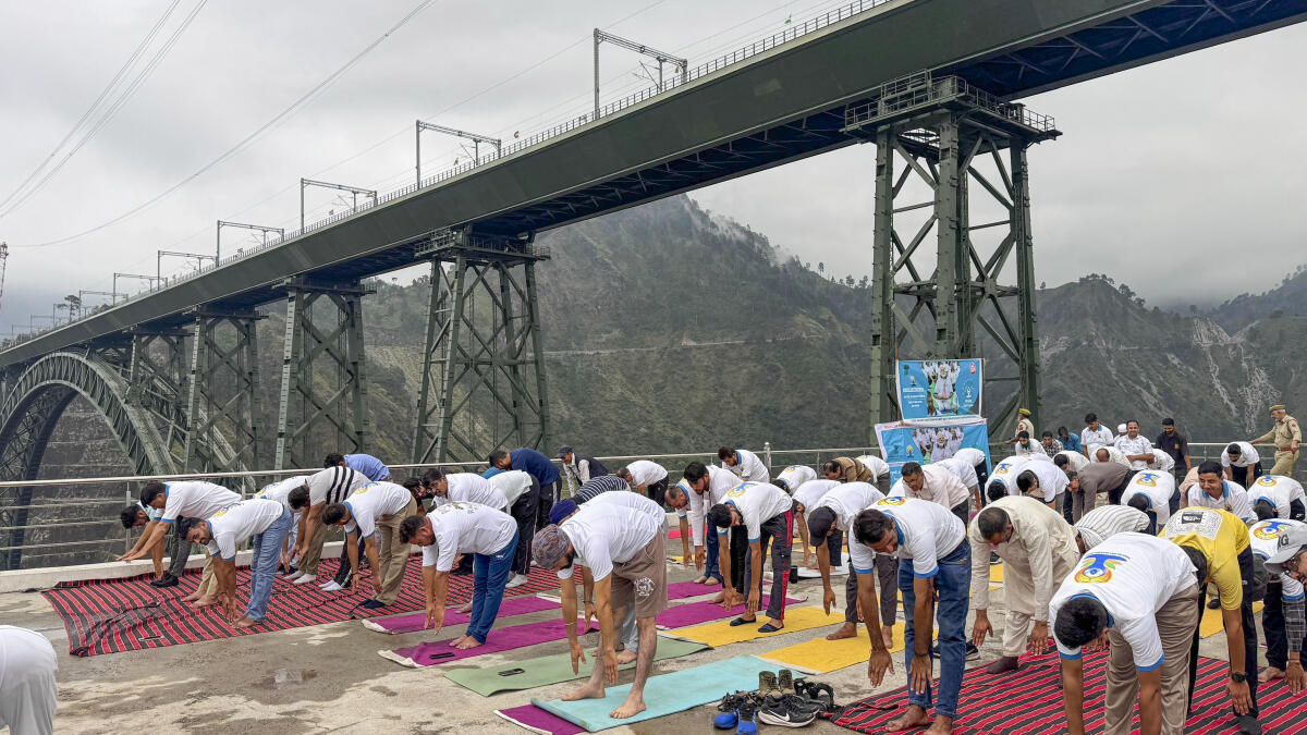 People perform yoga on the occasion of ‘11th International Day of Yoga’, near the Chenab Bridge, in Reasi district, Jammu and Kashmir.