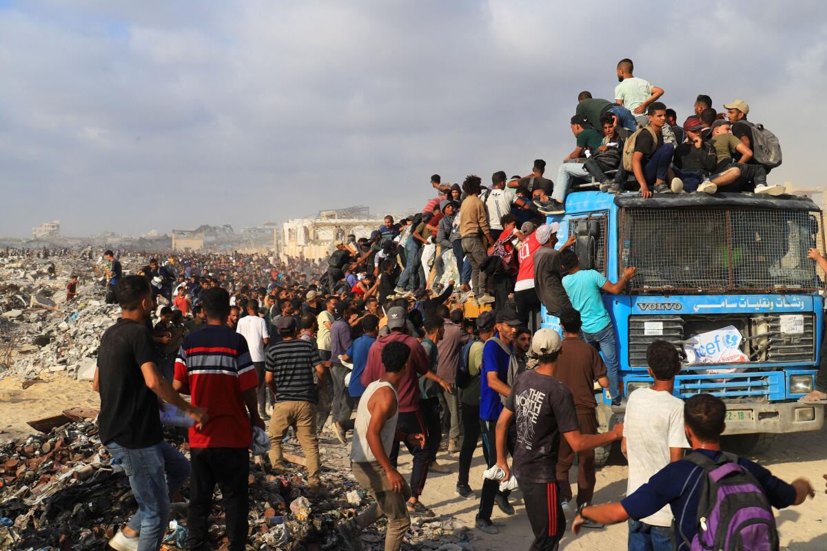 Palestinians gather to receive aid supplies in Beit Lahia