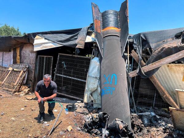 A man poses next to apparent remains of a ballistic missile following missile attack by Iran on Israel