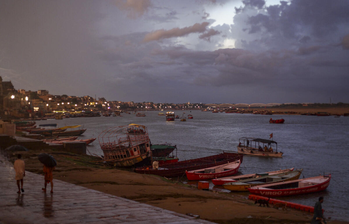 Boats stand anchored as it rains, at a ghat on the banks of the Ganga river, in Varanasi, Uttar Pradesh