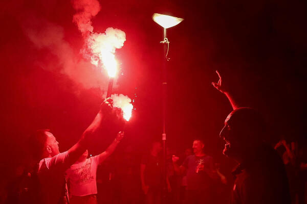 People hold smoke flares during an anti-government protest by Serbian students and other demonstrators, demanding snap elections, near the Slavija Square, in Belgrade