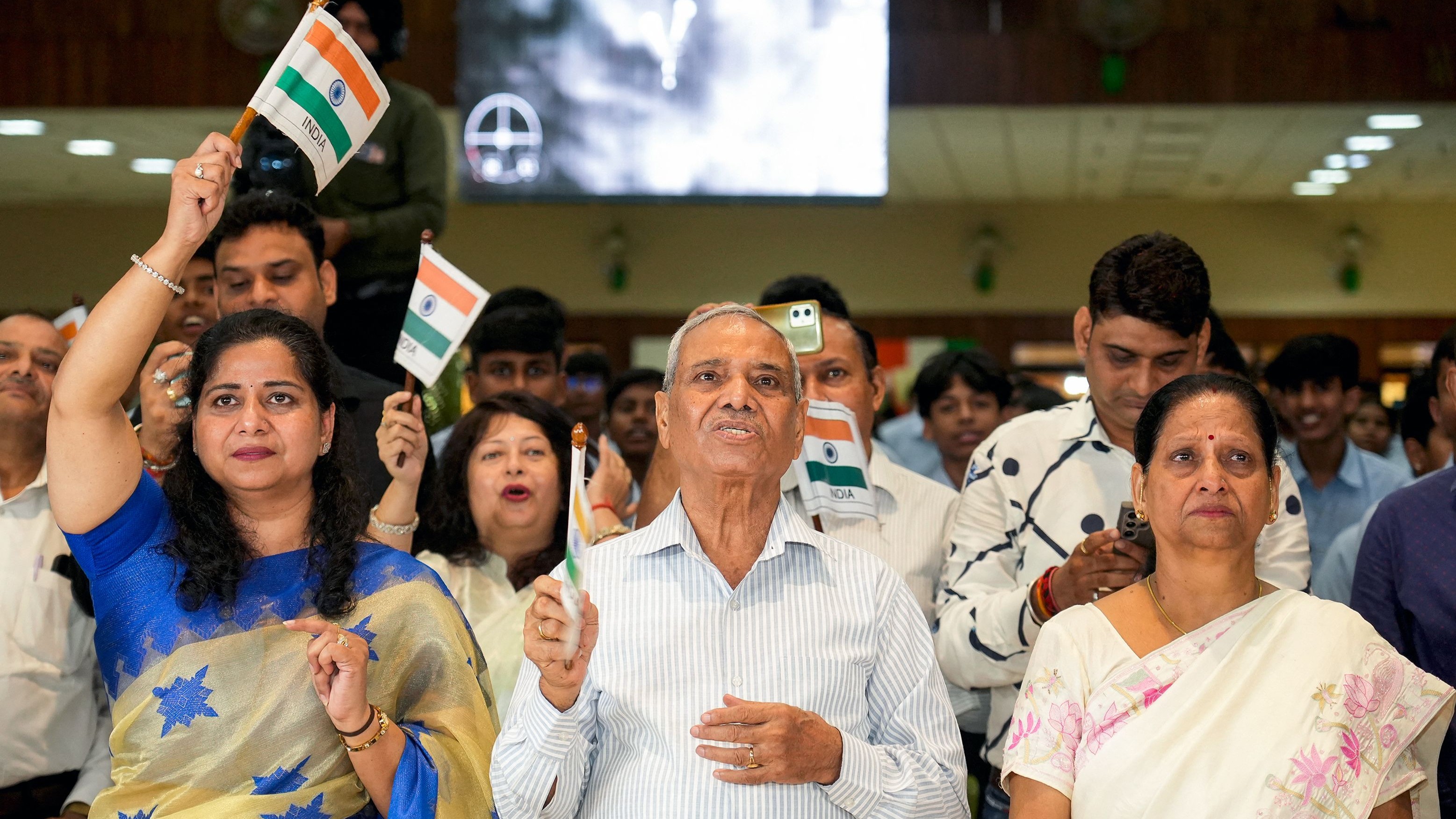 Moments before the capsule landed, an emotional parents waves the Indian flag celebrating their son's remarkable milestone.