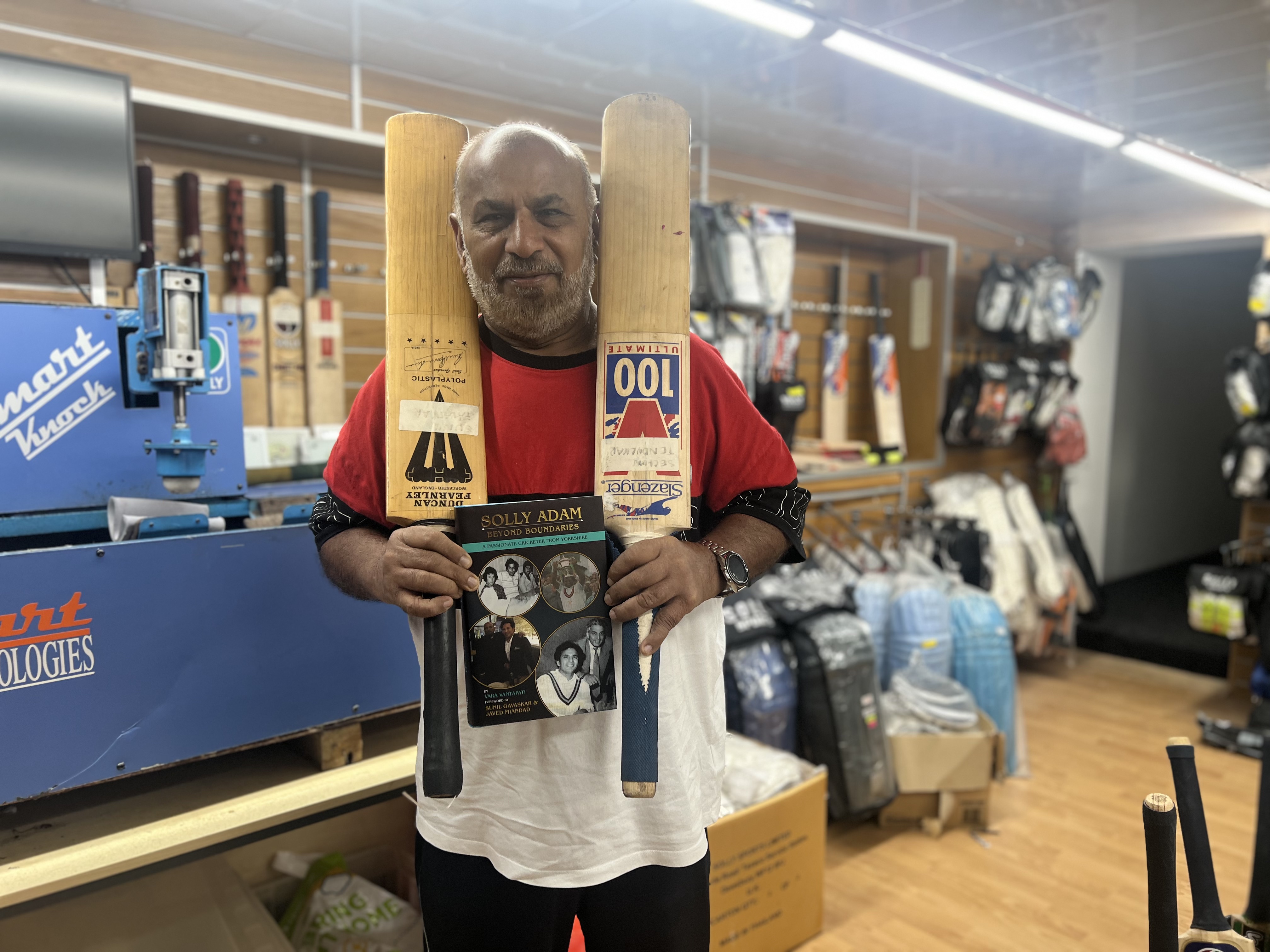 Solly Adam poses with the bats used by Sachin Tendulkar at his shop in Dewsbury. DH PHOTO/ SIDNEY KIRAN 