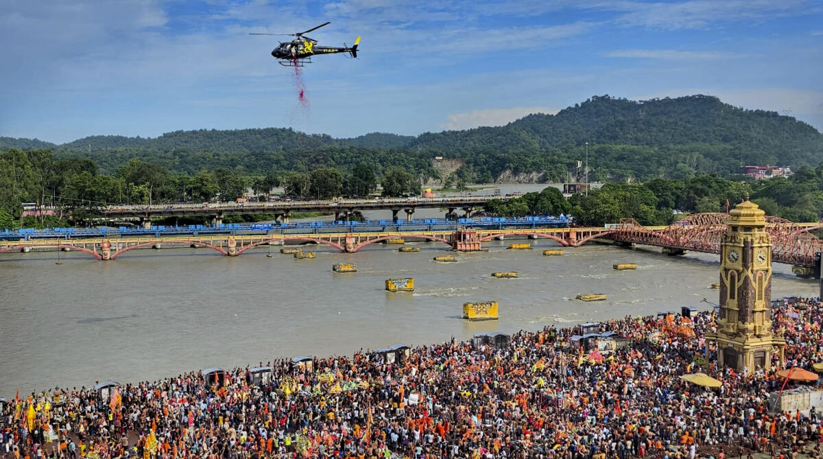 A helicopter being used to shower flower petals on 'Kanwariyas' amid the ongoing 'Kanwar Yatra', at Har Ki Pauri Ghat in Haridwar.