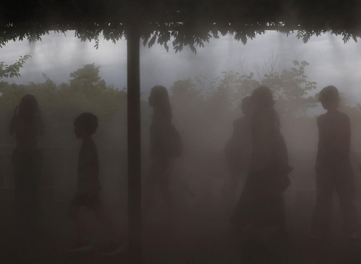 Visitors walk through cooling mist at Kiyomizu Temple in Kyoto.