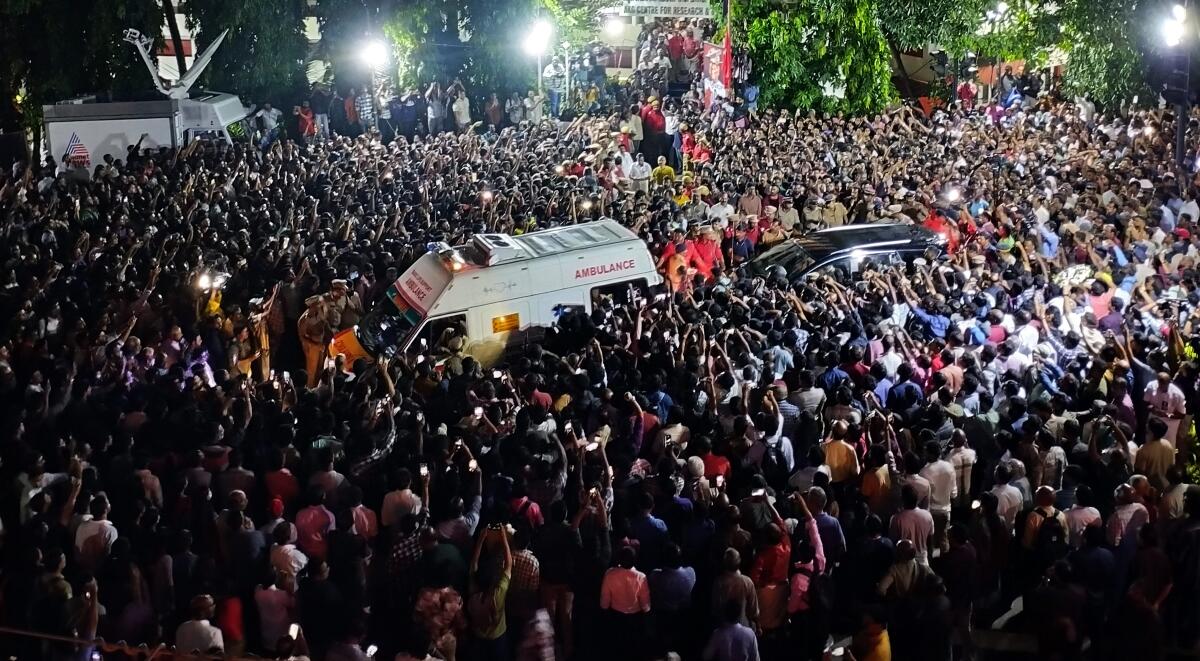 People gather outside the AKG Centre to pay their respects as the mortal remains of former Kerala chief minister and veteran CPI(M) leader V S Achuthanandan being brought in an ambulance, in Thiruvananthapuram.