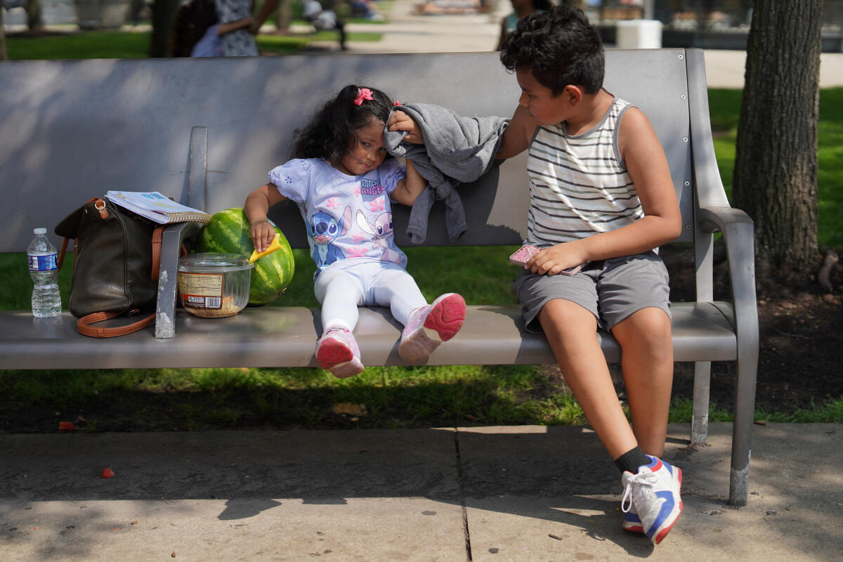 Jareht Alexander, 10, wipes sweat off of his sister, Leslie Juliani, 2, in Millennium Park as extreme heat and rising summer temperatures hit Chicago, Illinois, US.