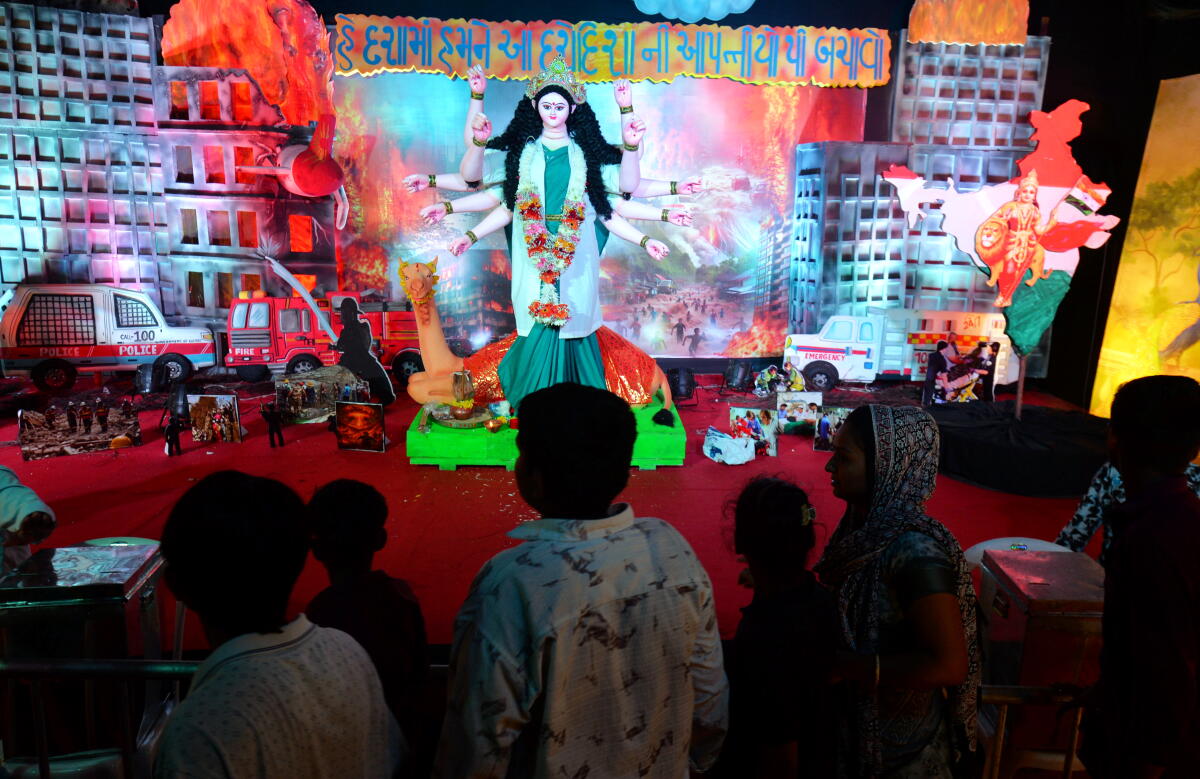 People visit a pandal decorated in a theme representing the recent Air India plane crash on the first day of the annual 10-day long ‘Dashama Vrat’ festival, at Meghaninagar area, in Ahmedabad, Gujarat.