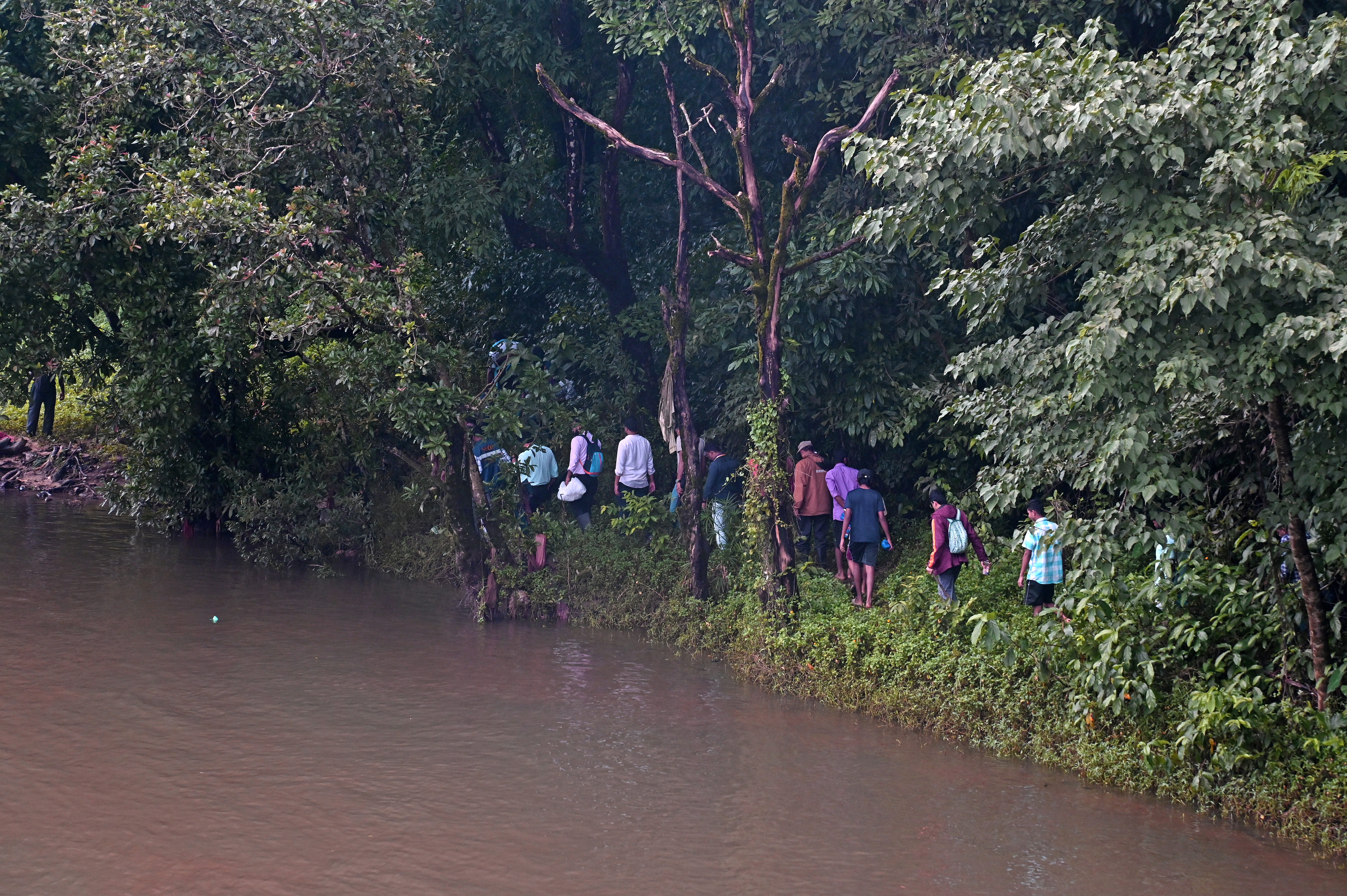 SIT members make a beeline to the sites on the bank of Netravathy river to begin exhumation process in Dharmasthala on Wednesday. DH photo/by Fakruddin H