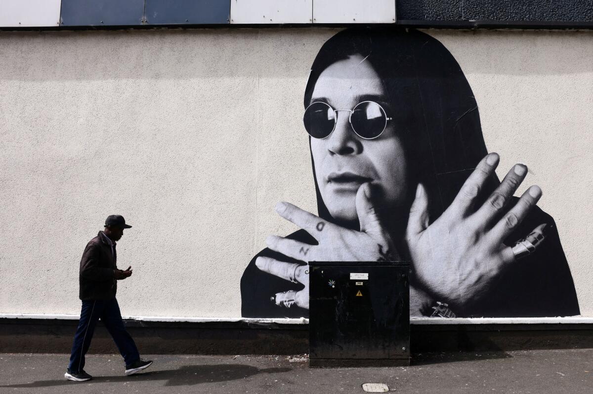 A man passes by a mural of Ozzy Osbourne, the former Black Sabbath frontman, ahead of the funeral cortege, in Birmingham, Britain, July 30, 2025.