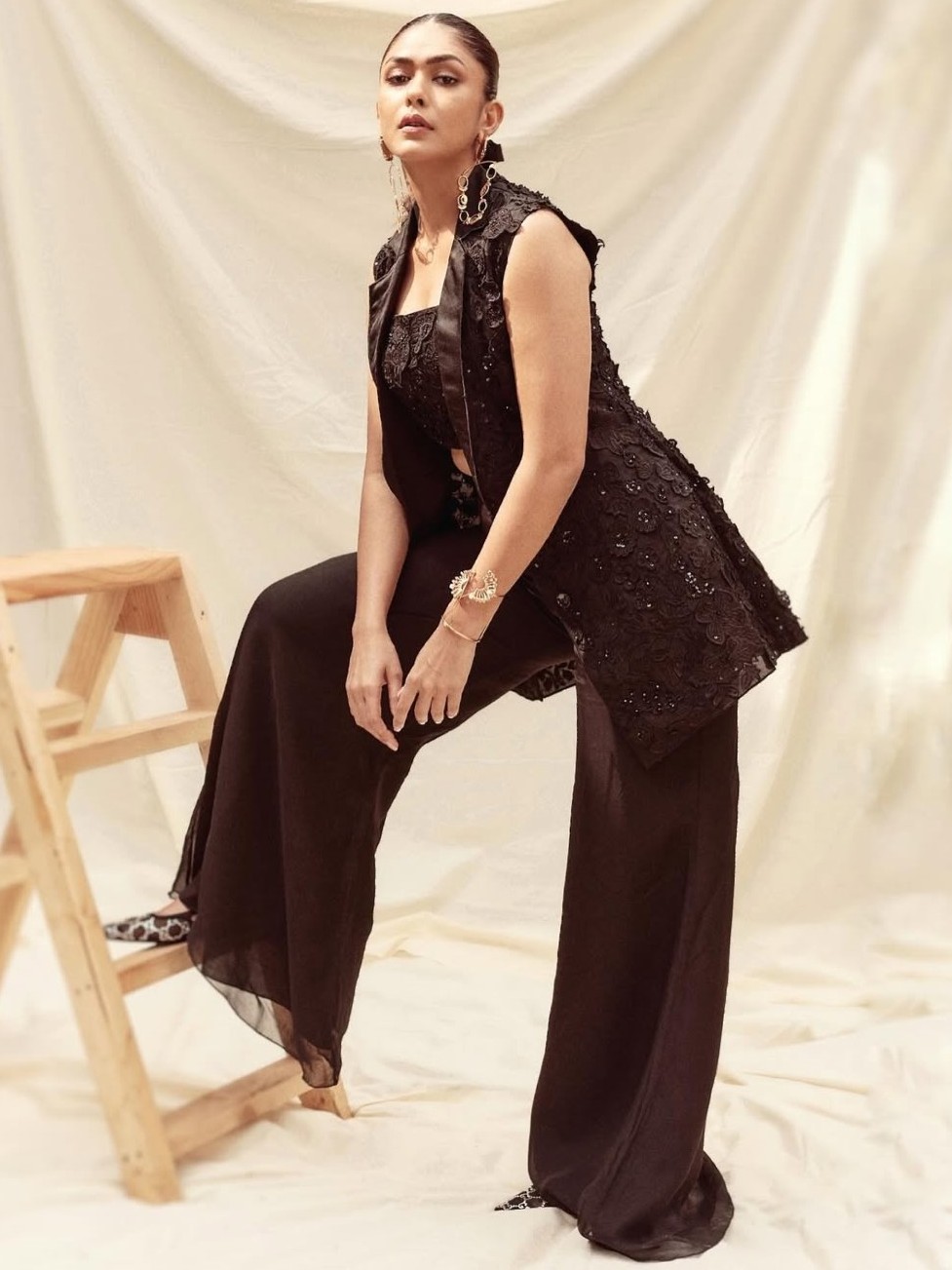 Mrunal made a bold style statement in an all-black co-ord set, layered effortlessly with a matching embellished coat. A touch of drama in her hair and oversized earrings paired with a sleek bracelet elevated the entire look.