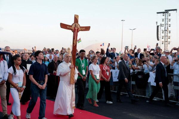 Pope Leo XIV carries a cross as he arrives to attend a vigil for the Jubilee of Youth in Tor Vergata, Rome, Italy.