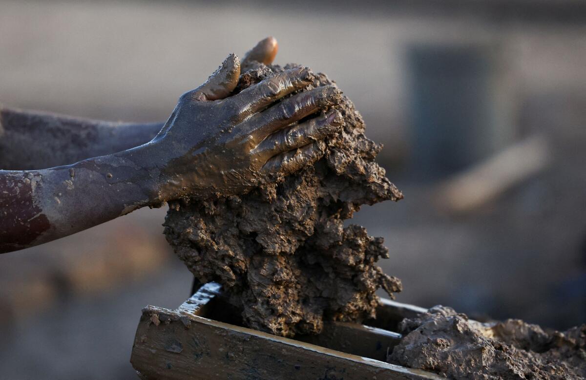 A brickmaker prepares mud to make bricks in Maseru, the capital of Lesotho, August 3, 2025.