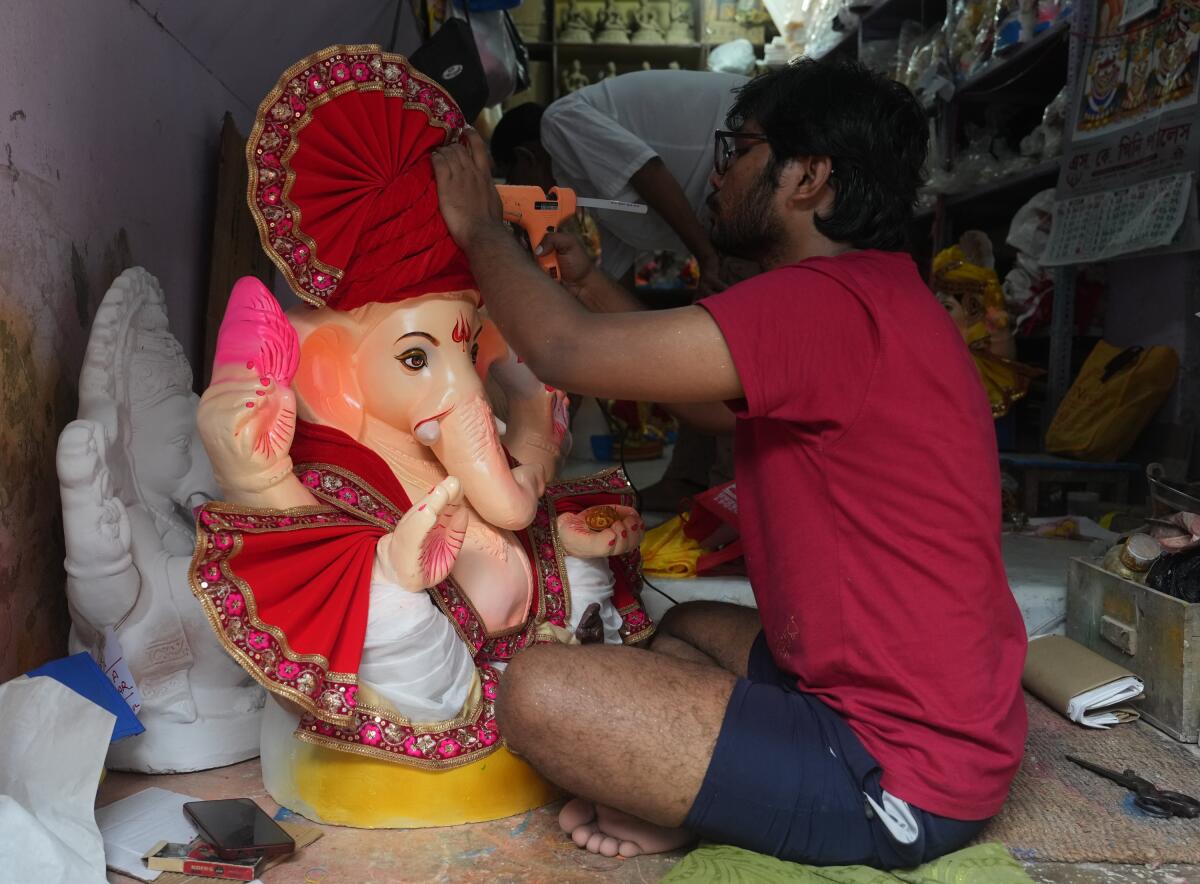 An artist gives final touches to an idol of Lord Ganesha ahead of Ganesh Chaturthi, at Kumartuli, in Kolkata, Sunday, Aug. 3, 2025.
