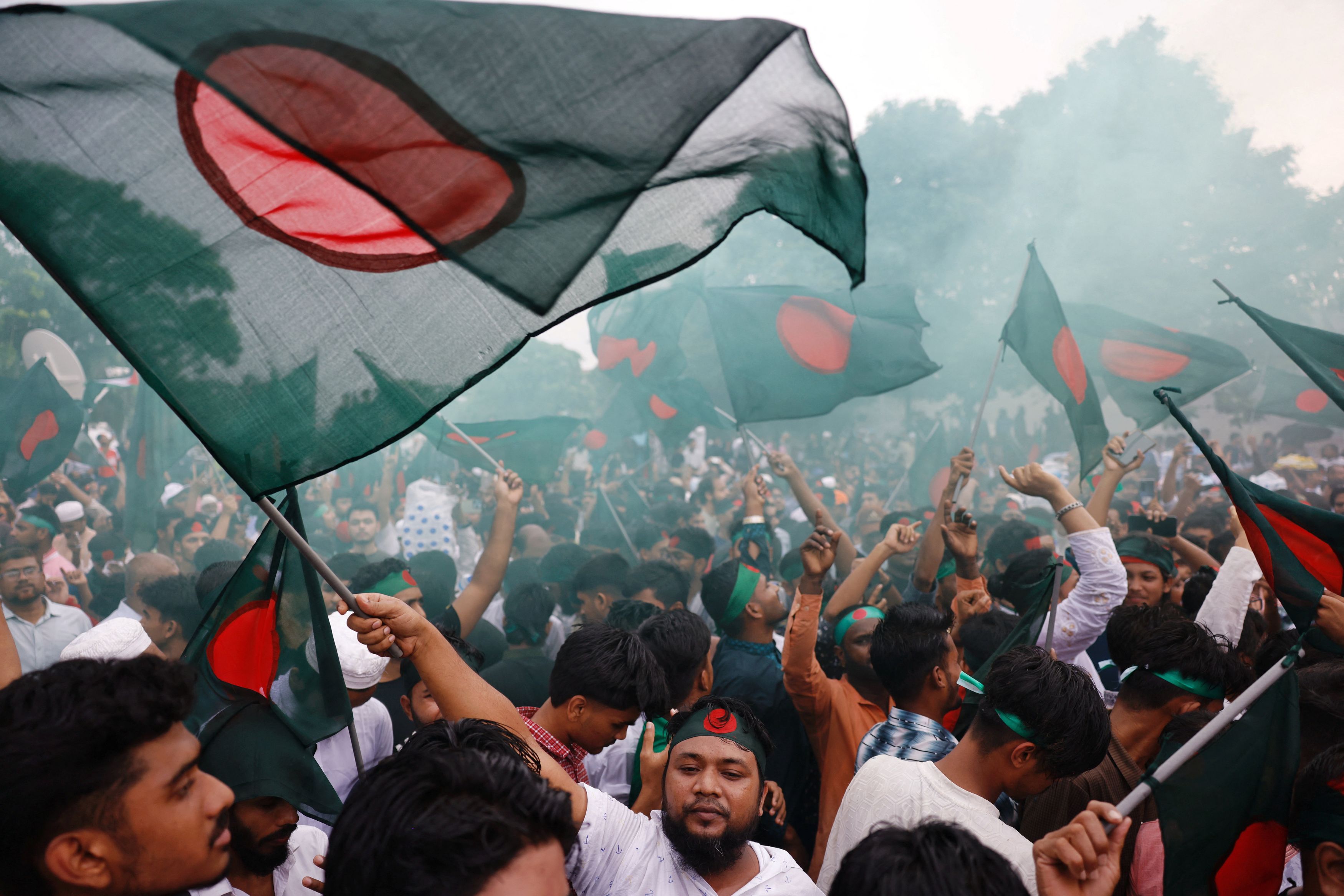 People wave flags during celebrations marking the one-year anniversary of student-led protests that led to the ousting of Bangladeshi then-Prime-Minister Sheikh Hasina, at Manik Mia Avenue, outside the parliament building, in Dhaka, Bangladesh, August 5, 2025. 
