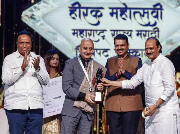 Maharashtra Chief Minister Devendra Fadnavis with Deputy CM Ajit Pawar felicitates Bollywood actor Anupam Kher during the diamond jubilee ceremony of the Maharashtra State Marathi Film Awards, in Mumbai.