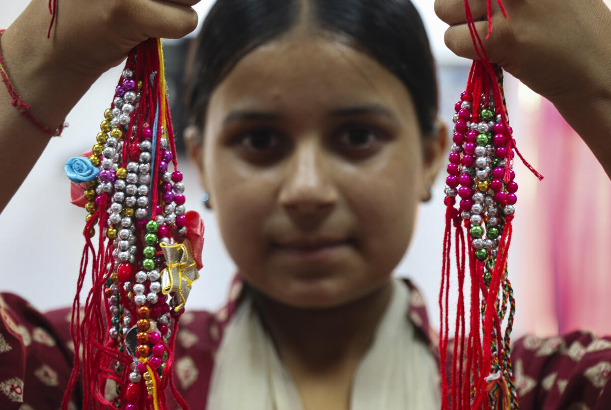A student of the Seva Bharti Ashram prepares 'rakhis' for security personnel guarding the Indo-Pak border, ahead of the 'Raksha Bandhan' festival, on the outskirts of Jammu.