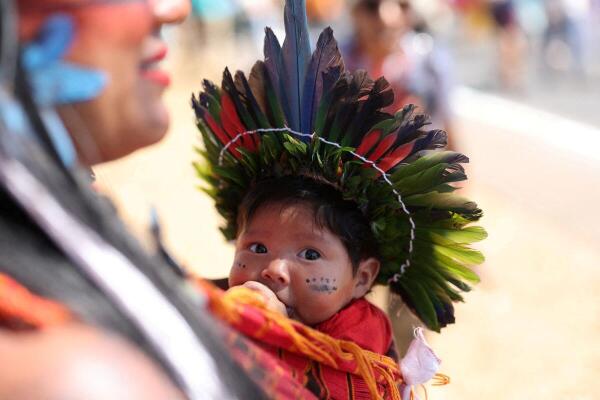 An indigenous child looks on as people attend the IV March of Indigenous Women, in defense of women's rights, local indigenous people and the environment, in Brasilia, Brazil.