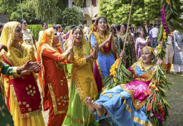College students wear traditional attires during the 'Teej' festival celebration at Shahzada Nand College, in Amritsar, Punjab.