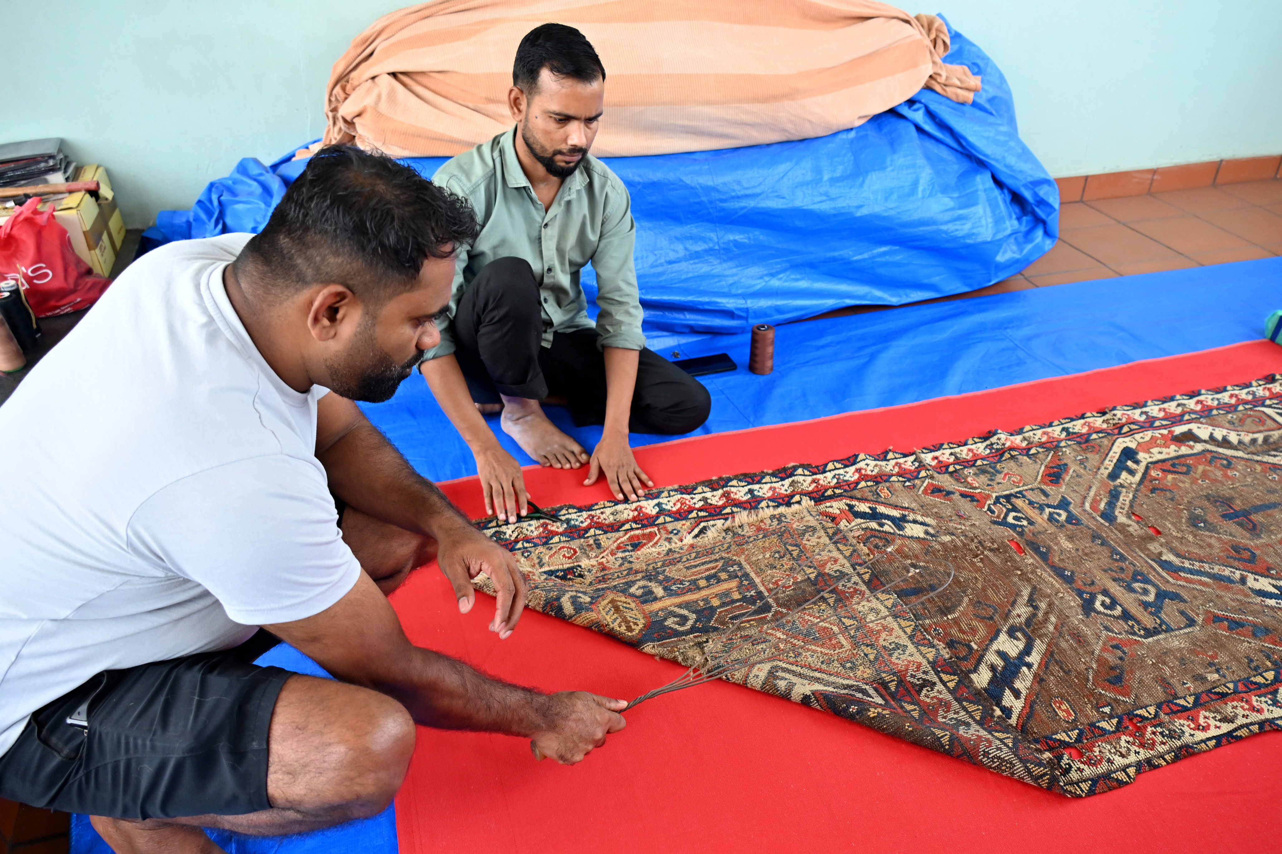 Imran Malik (right) and Jose George help Mehra conserve and manage his collection.
