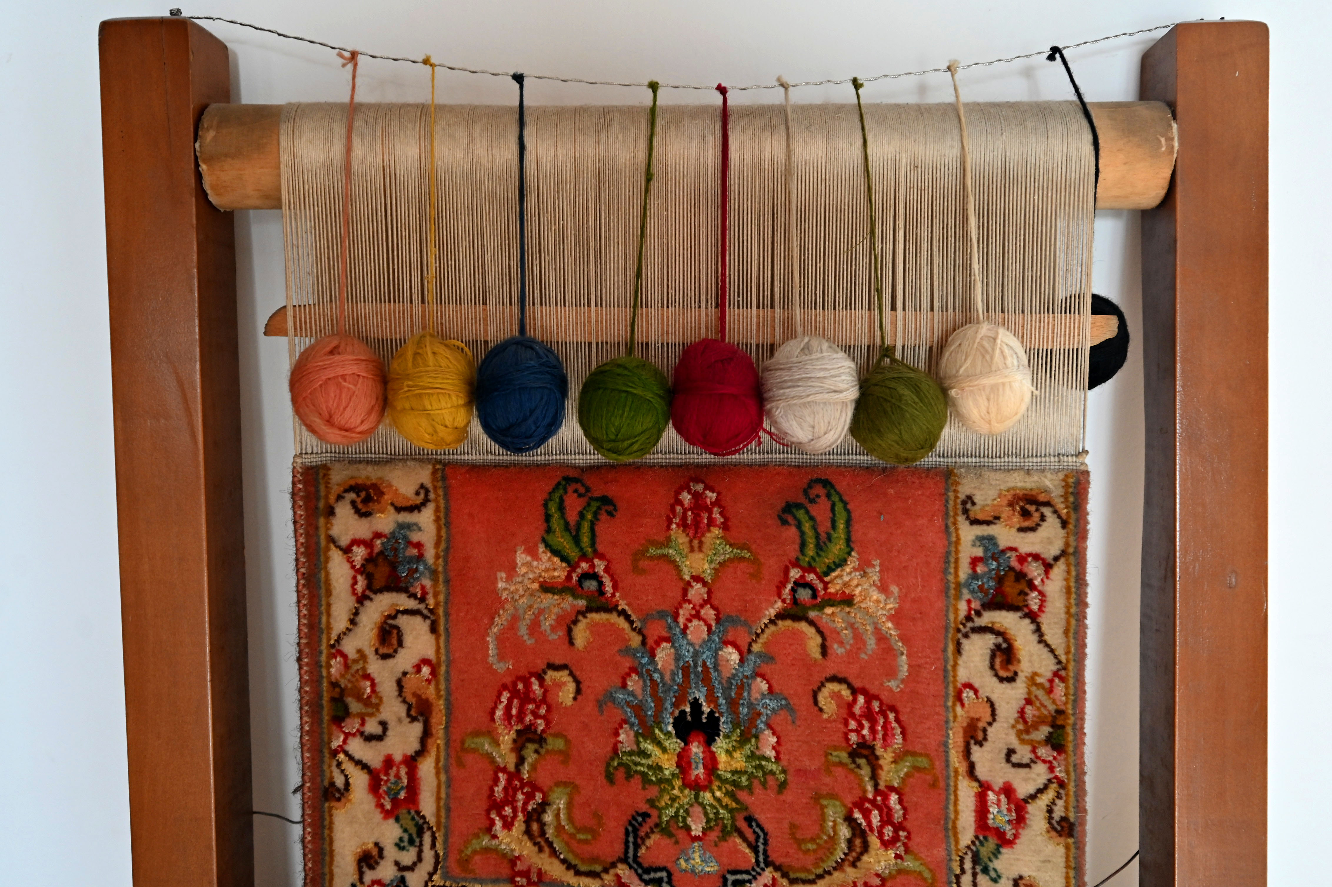 An unfinished carpet, set on a loom, is displayed in Danny Mehra's studio.