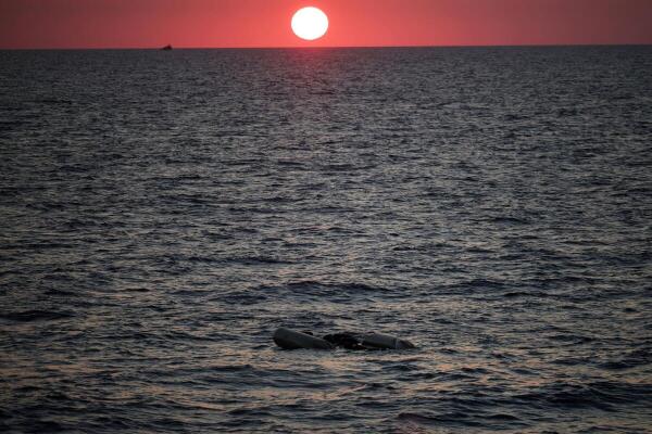 A rubber boat used by migrants floats at the sea on sunset, as seen from the migrant search and rescue ship Sea-Watch 5, operated by German NGO Sea-Watch, in the search and rescue (SAR) zone in the central Mediterranean, off Libya.