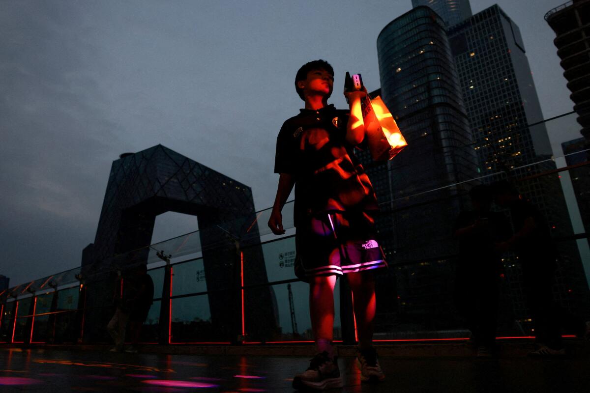 A person walks on a terrace of a shopping mall at the central business district (CBD), in Beijing, China.