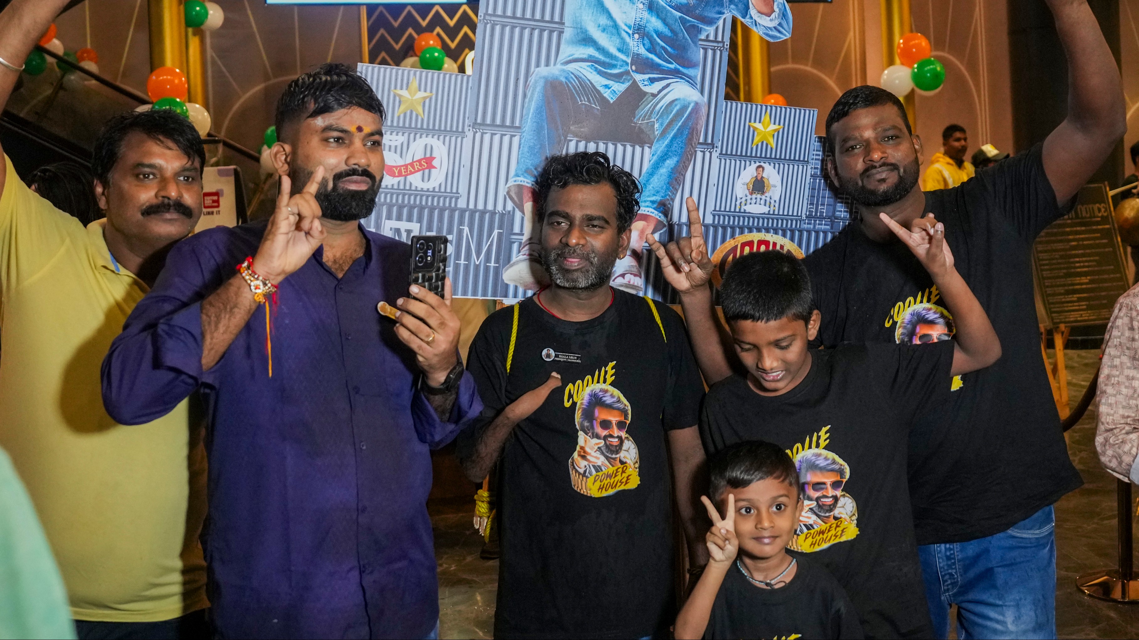 Fans of superstar Rajinikanth pose for the photographs during the first day first show celebrations of Coolie in Mumbai.