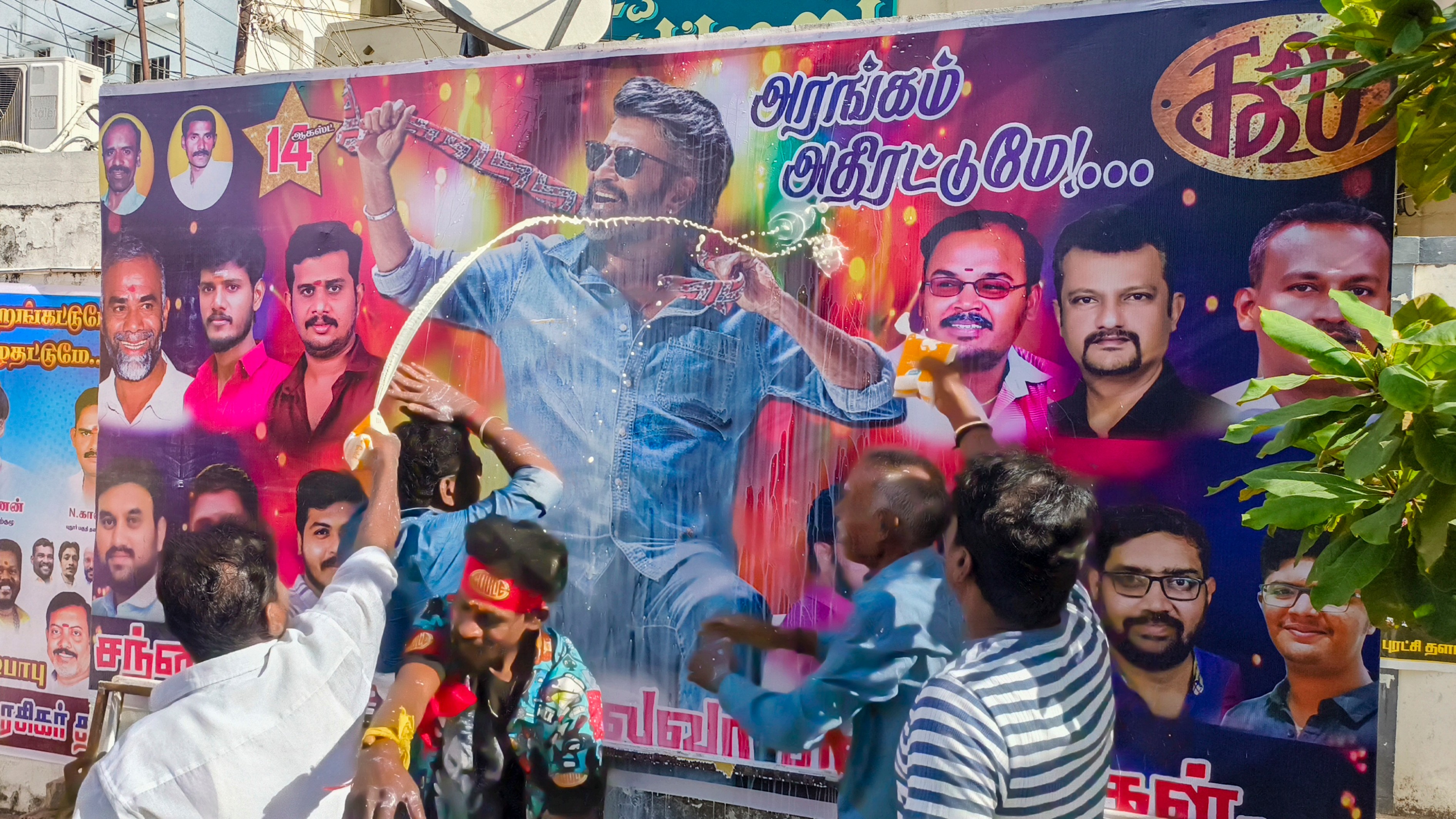 Fans of superstar Rajinikanth pour milk on the posters as they celebrate the release of Coolie in Madurai.