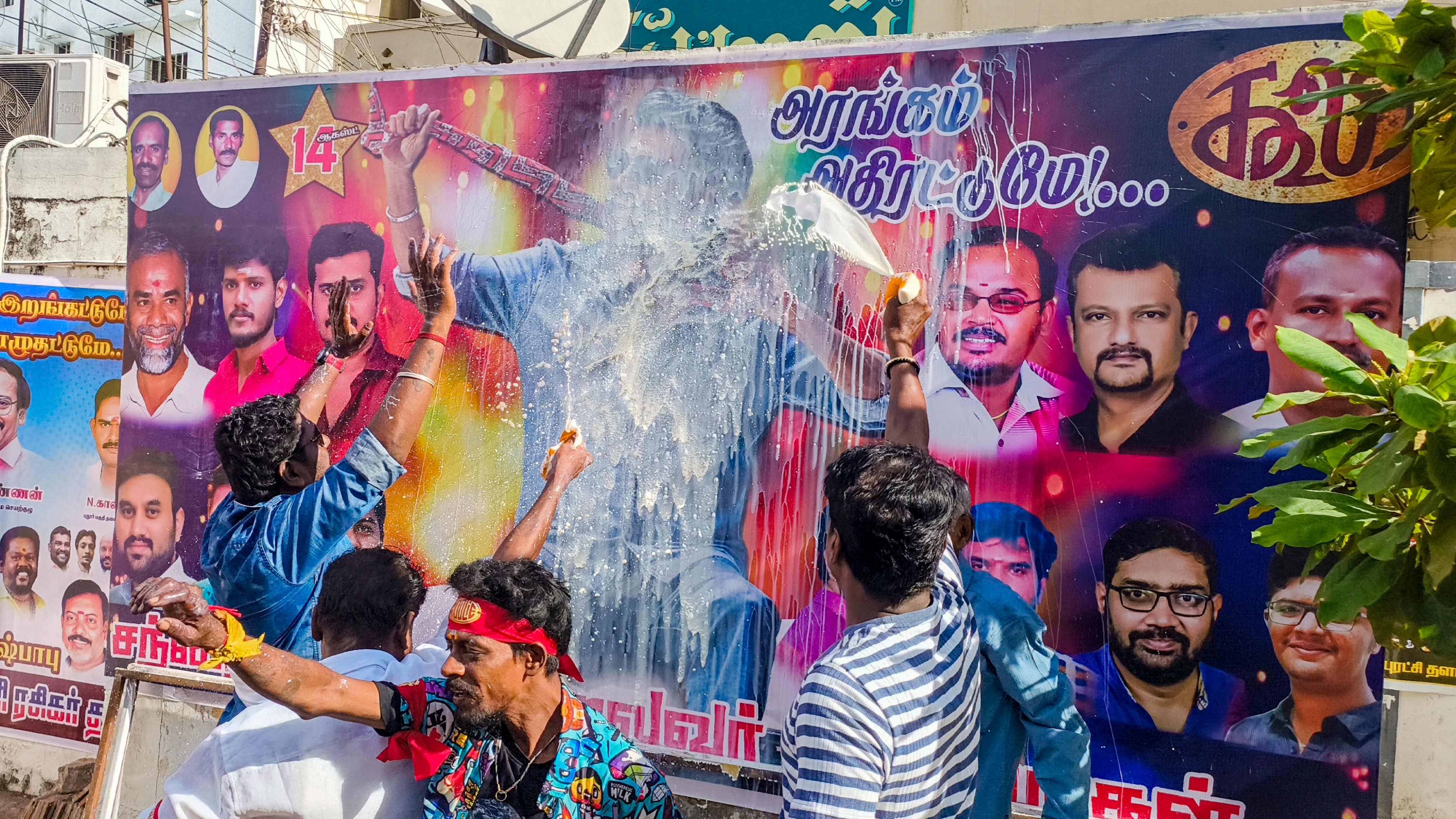 Fans of superstar Rajinikanth pour milk on the posters as they celebrate the release of Coolie in Madurai.
