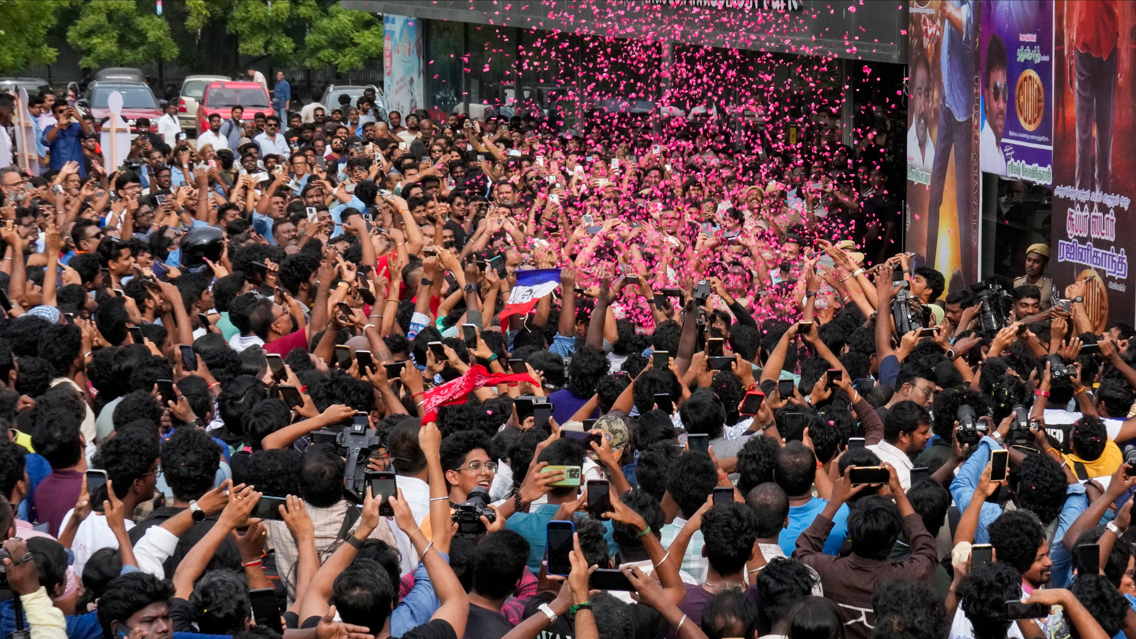 Fans of superstar Rajinikanth celebrate the release of Coolie outside a movie theater in Chennai.