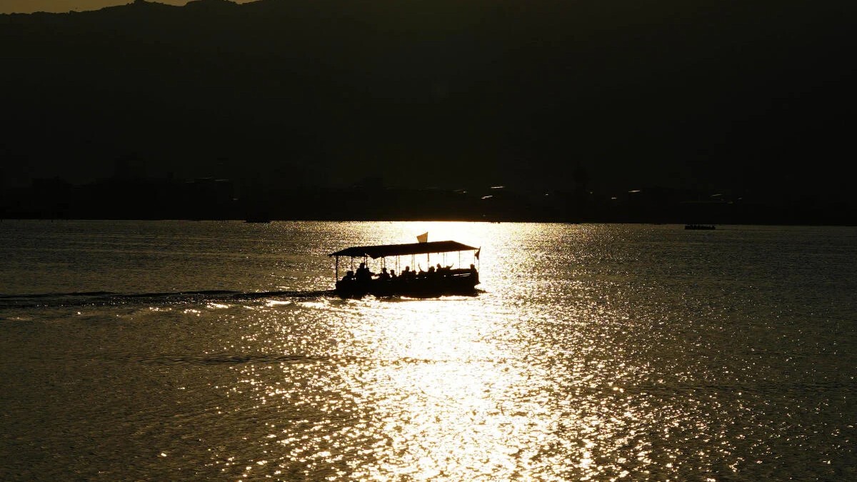 Tourists take a boat ride at Ana Sagar Lake during sunset, in Ajmer, Rajasthan.