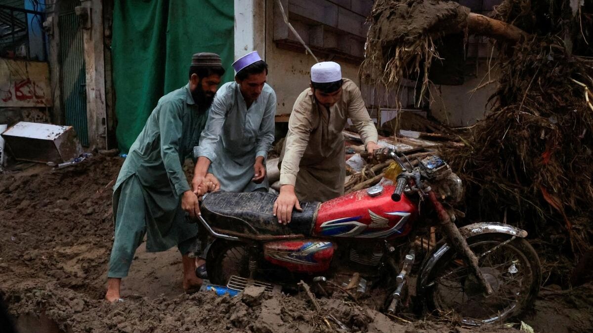 Men retrieve a motorbike from a thick layer of mud, following a storm that caused heavy rains and flooding in Pacha Kalay Bazar, in Buner district, in Khyber Pakhtunkhwa province, Pakistan.