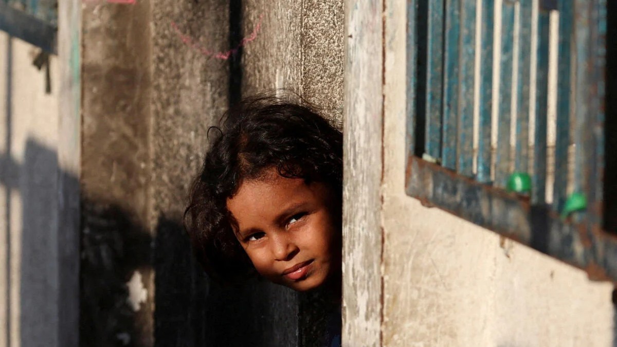 A Palestinian child displaced by the Israeli military offensive looks on from a shelter at an UNRWA school in Deir Al-Balah, in the central Gaza Strip.