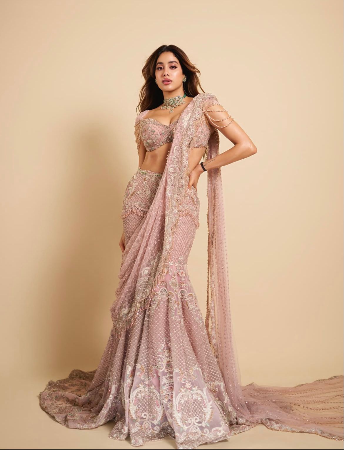 Janhvi Kapoor
stuns in a heavy drape featuring heavy embellishments all across and layered strings around the borders of her sleeves. Keeping it loaded with accessories she tops her look with heavy traditional jewellery and serves major traditional fashion goals.